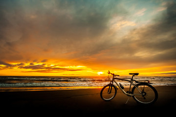 Fototapeta na wymiar Tourist bike on the coast of the sea at sunset time