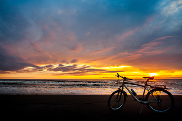 Fototapeta na wymiar Tourist bike on the coast of the sea at sunset time