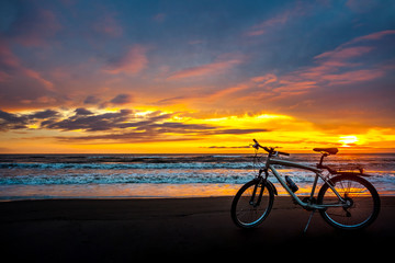 Fototapeta premium Tourist bike on the coast of the sea at sunset time