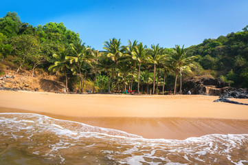 Paradise beach in Gokarna. Beautiful deserted landscape with clean sand and wave. View from the sea to the shore. - obrazy, fototapety, plakaty