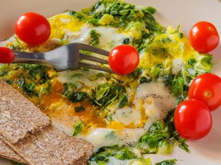 Breakfast tasty and nutritious to cook the eggs in vegetable olive oil with fresh herbs on a platter to add a few cherry tomatoes and muesli bars.