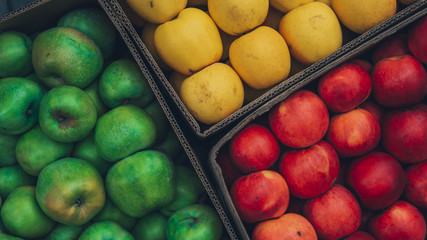 Red and yellow and green juicy apples in a box. apple background.