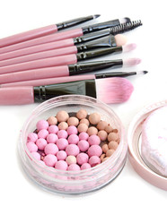 Make-up brushes set with powder balls in box on white.