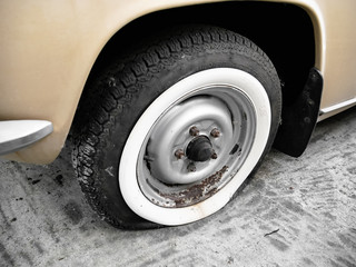 Flat tire of old car, detail and close up, nostalgia for a time which has passed 