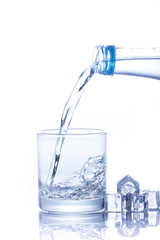 Water is poured into a glass with ice cubes