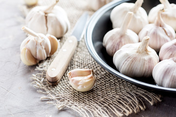 Garlic cloves and garlic bulb on black plate.Spicy cooking ingredient. Natural herbal medicine vegetable.