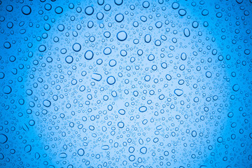 Rain droplets on blue glass background, Water drops on glass.