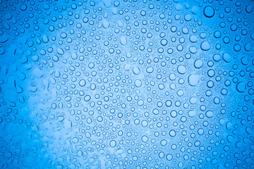 Rain droplets on blue glass background, Water drops on glass.