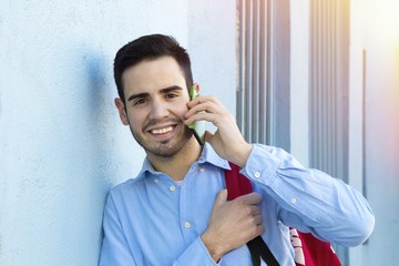 young man with cellphone in the street of the city