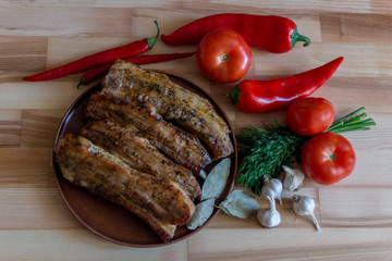 Grilled pork chop with bay leaf, pepper, garlic and dill on wooden board - selective focus