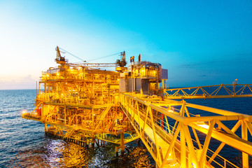 Offshore construction platform for production oil and gas with bridge in evening time