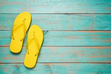 Flip-flop, Sandal, Summer. Yellow flip flop sandals on blue wood