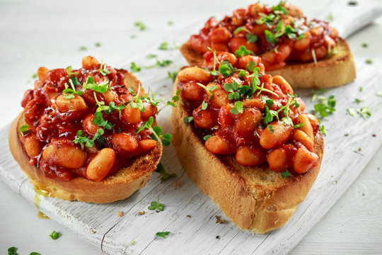 Beans fried in tomato sauce on toasted bread with cross salad sprinkle