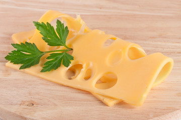 cheese slice with leaf parsley on cutting board