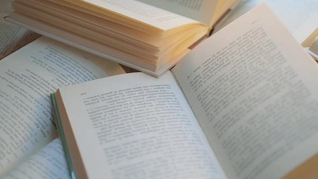 Dolly shot over many open books