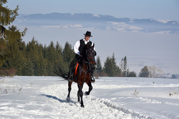 young man riding horse outdoor in winter