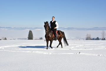 young man riding horse outdoor in winter