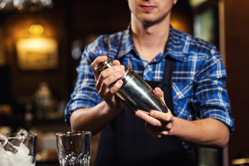 Barman at work,Barman pouring hard spirit into glasses in detail,Bartender is pouring tequila into glass,preparing cocktails,concept about service and beverages