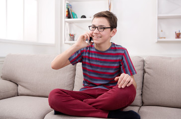 Obraz premium Teenager has phone talk in living room at home