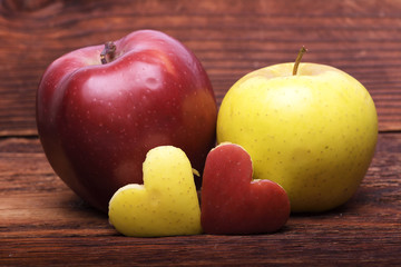 Two apples with heart on wood