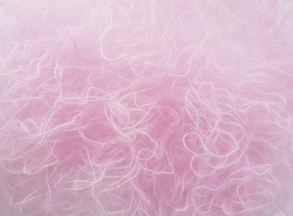 Fototapeta premium A skein of fine wool yarn. Thread crochet closeup. Materials for needlework. Pink and gray thread. Yarn for knitting. Abstract background with threads.