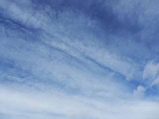 blue sky with white diagonal clouds