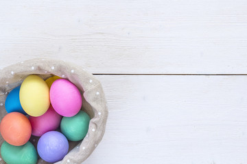 Basket with easter eggs on white background and copy space. Top view.