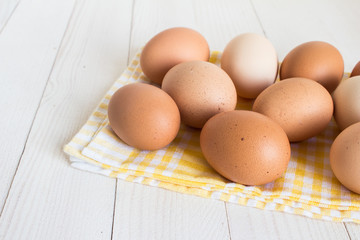 Fresh eggs in carton package on white wood background