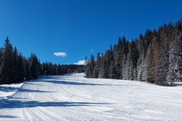 Corvara, Alta Badia winter view of ski slope with blue sky, no people - 141125335