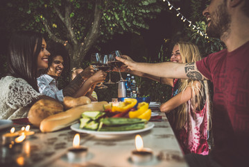 Group of friends making barbecue in the backyard at dinner time
