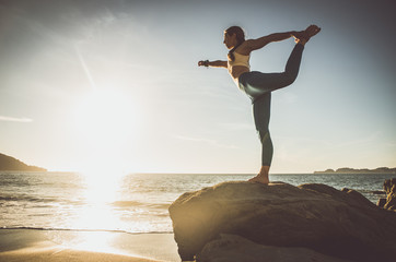 Fototapeta na wymiar Woman making yoga poses in Baker beach, San francisco