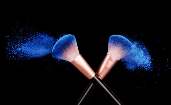 Makeup brushes applying powder on black
