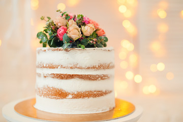Decorated by flowers white naked cake, rustic style for weddings, birthdays and events.