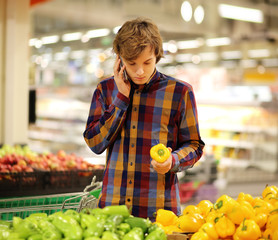 Young man buying vegetables at the market   .Young man in the supermarket .