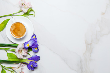 Morning romantic breakfast. Coffee and flowers on marble background. Top view