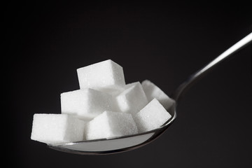 teaspoon with pile of lump white sugar