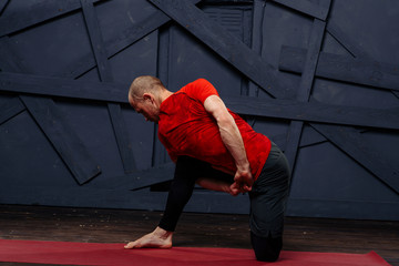 Fototapeta premium Man practicing advanced yoga against a urban background