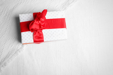 Gift books beautifully wrapped and bandaged with a red ribbon bow on a white coverlet