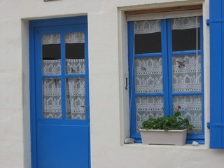 Fototapeta na wymiar Una finestra e una porta dipinte d'azzuro in Francia.