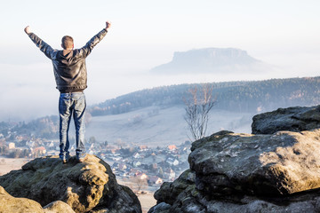 Eine Person steht auf den Bergspitze bei Sonnenschein