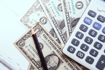 Fototapeta premium Calculator with american dollars on the wooden table background, finance concept