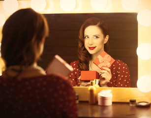 photo of beautiful young woman holding her gift near the window with lights