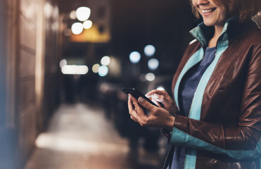 Girl smile pointing finger on screen smart phone on background illumination color light in night...