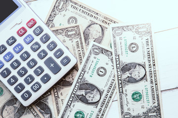 Fototapeta premium Calculator with american dollars on the wooden table background, finance concept