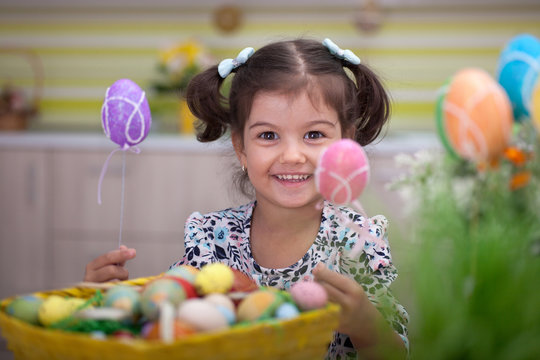 Cute little girl with basket full of colorful easter eggs