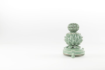 Horizontal image of a green glass incense burner oriented to the right of the image