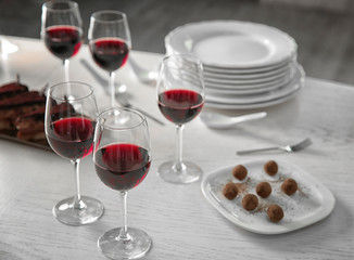 Red wine and delicious chocolate desserts on white table