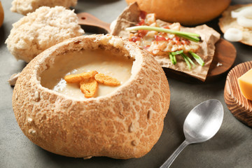 Delicious cream soup in bread on table