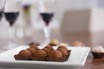 Delicious chocolate truffles on plate closeup