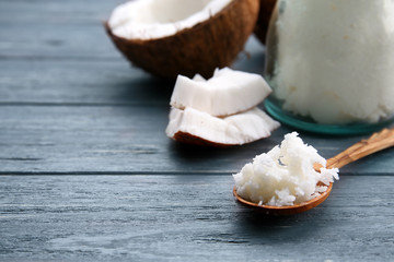 Spoon with fresh coconut oil on wooden background